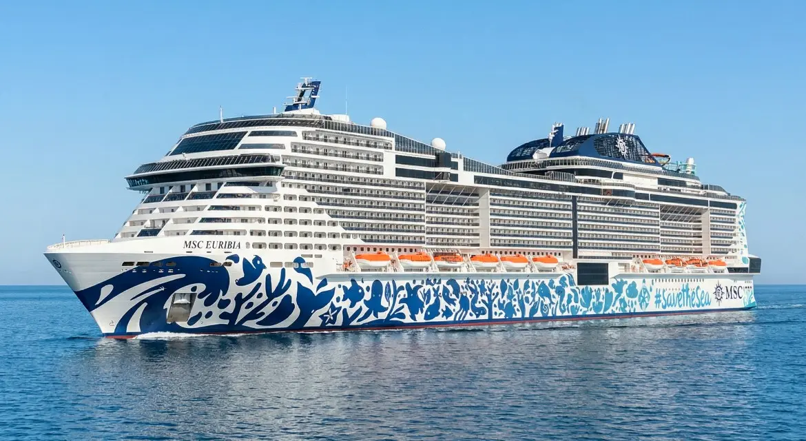 MSC Cruises 2026 brand collection: side view of a modern flagship at sea with a majestic mountain backdrop, representing Mediterranean heritage. Experience MSC in 2026. Explore global destinations with a signature blend of European elegance and modern ship innovation.