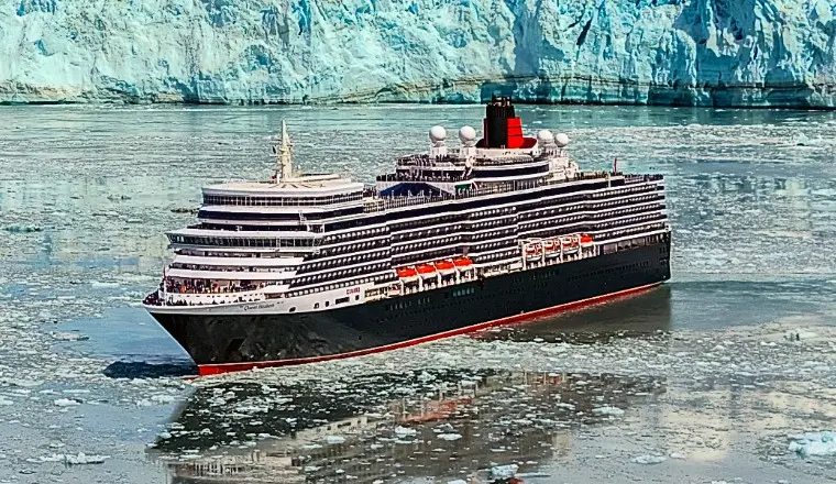 Side view of a classic Cunard ocean liner sailing on calm open waters.