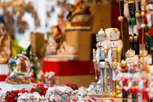 Un puesto en el mercado navideño que exhibe cascanueces, figuras de Papá Noel, coronas y otras decoraciones festivas.