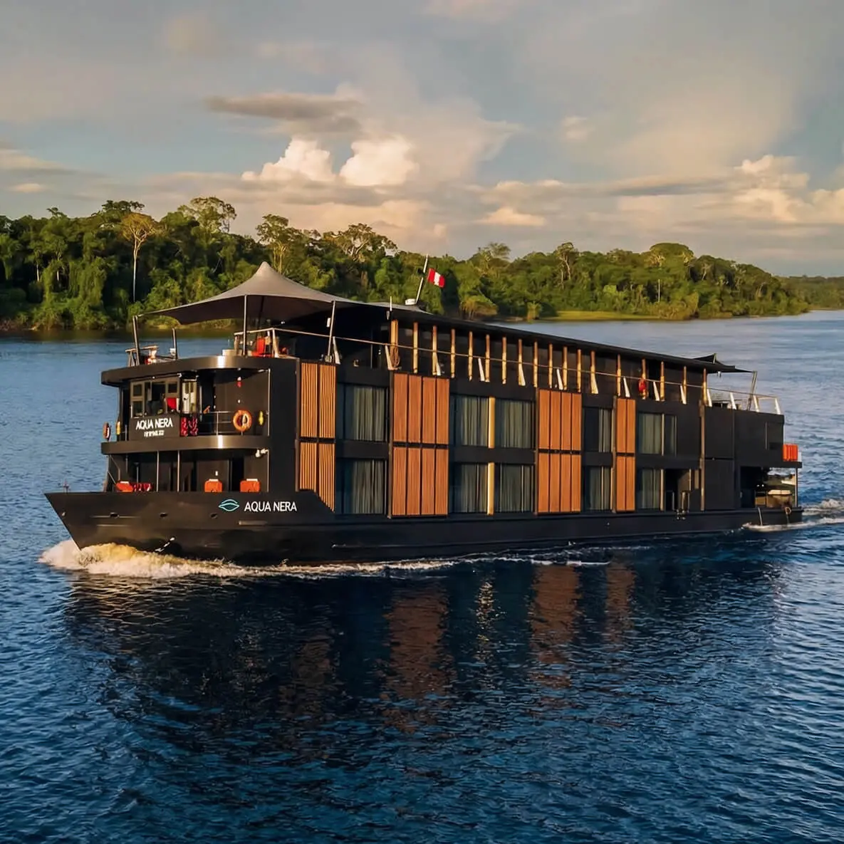 Setting a new standard for luxury river cruising on the Amazon, Aqua Nera draws design inspiration from the Peruvian Amazon&rsquo;s mystical black water lagoons and bears the hallmarks of contemporary style and generous interiors that Aqua Expeditions cruise ships are known for. Aboard the Aqua Nera, award-winning architects Noor Design crafts every space to perfection. The vessel&rsquo;s 20 spacious Design Suites convey a sense of Amazon tranquility, while the social spaces showcase refined elegance with a touch of drama. Tastefully woven into the design are accents and details from the rubber boom era and the colorful cultures of Portugal, Spain and Peru.