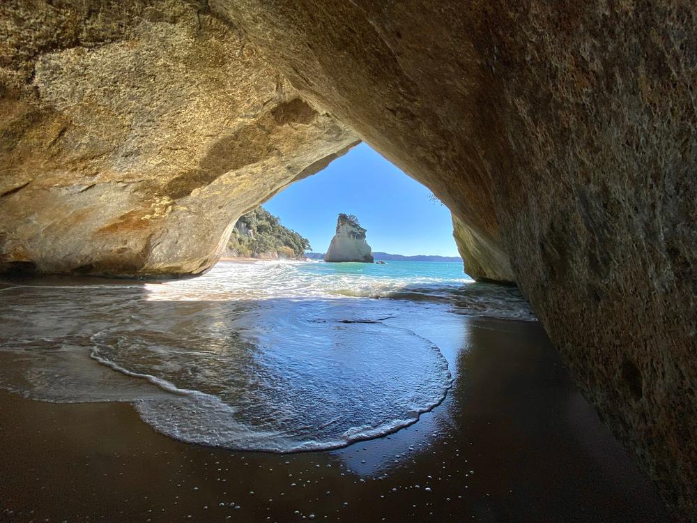Vista panorámica de una cueva marina costera con aguas turquesas y formaciones rocosas