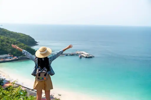 Mujer hermosa joven con mochila de viaje en solitario en la montaña de la isla tropical.
