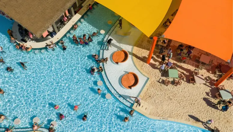 Overhead view of a Princess Cruise ship swimming pool crowded with people swimming, splashing, and enjoying water fun.
