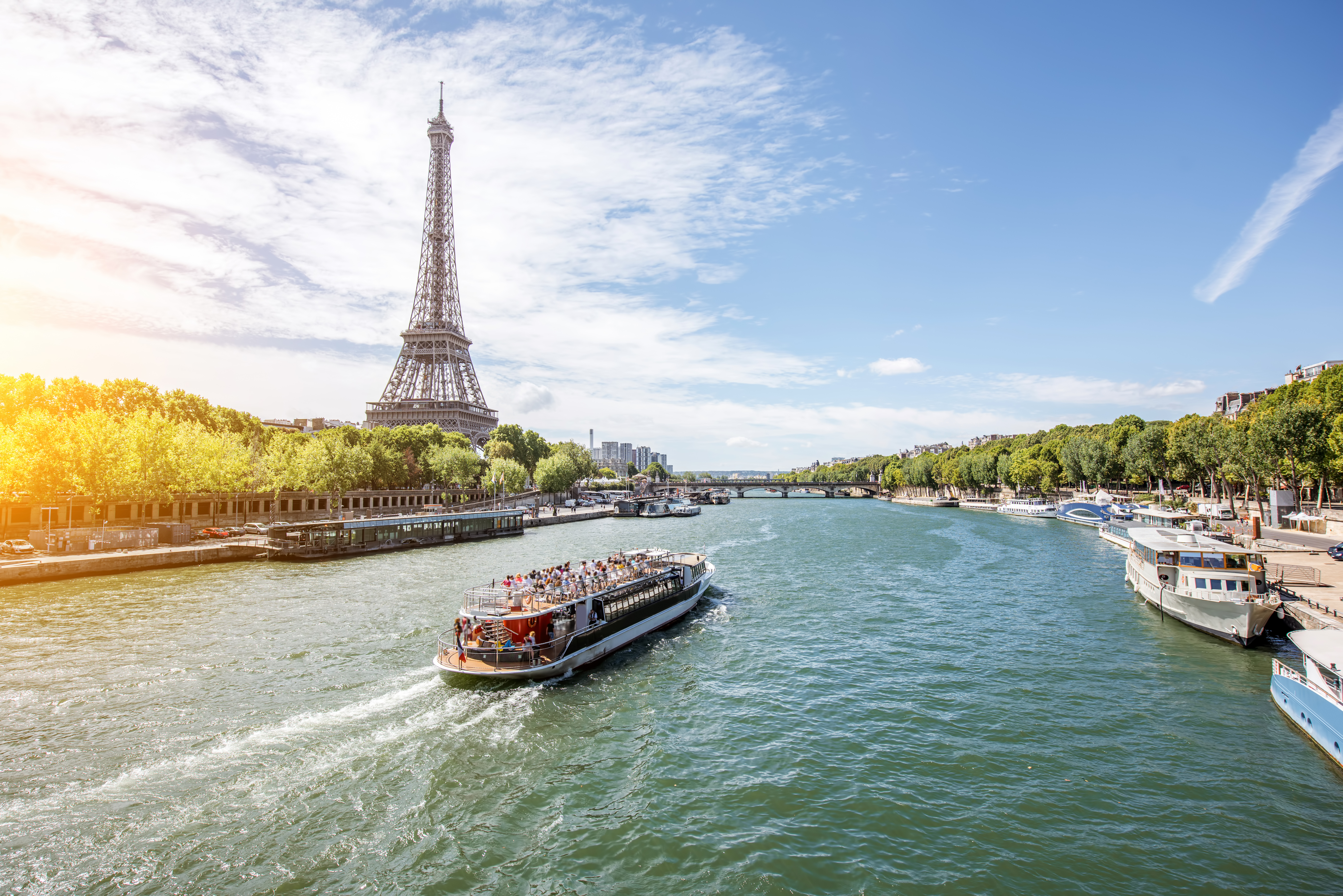 Landscpae view on the Eiffel tower and Seine river with tourist boat in Paris.