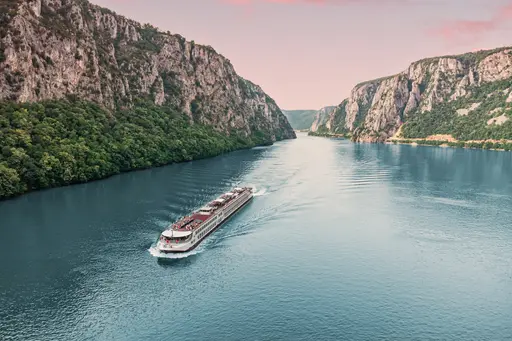 Un crucero por el río navegando en aguas tranquilas rodeadas de verdes montañas, un paisaje pintoresco y tranquilo.