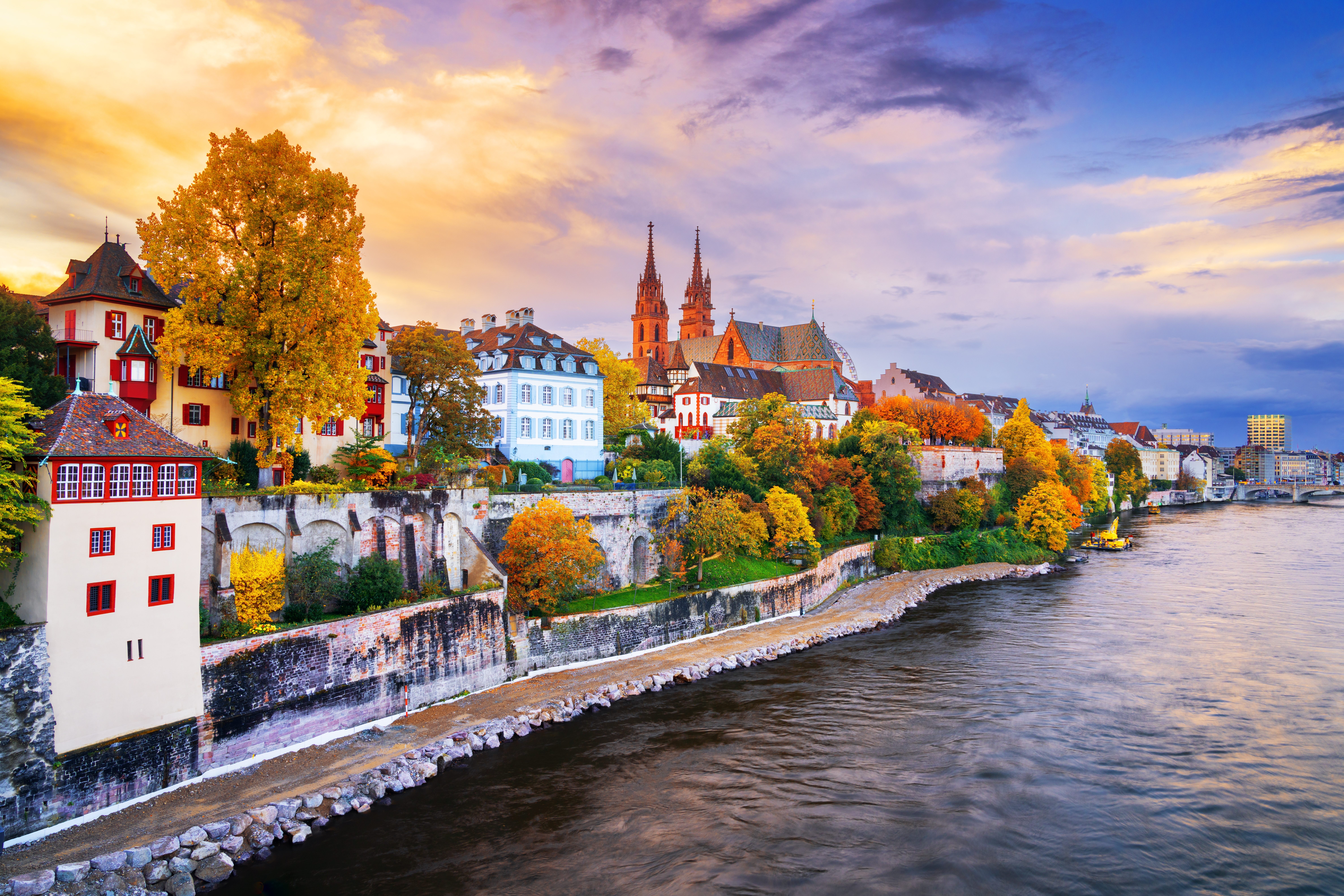 Basel, Switzerland on the Rhine River at dusk in autumn.