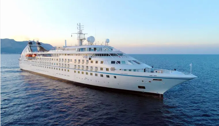 A stunning cover of a Windstar yacht at sunset, showcasing the 2026 luxury cruise collection and special sailing offers.