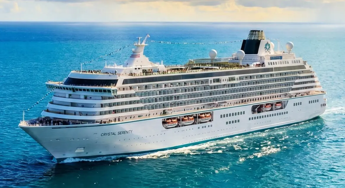 Crystal Cruises 2026 brand collection: elegant luxury ship sailing across tranquil ocean waters beneath a glowing Mediterranean sunset. Experience 2026 with Crystal Cruises. Enjoy refined dining, enriching entertainment, personalized service, and immersive journeys designed for sophist