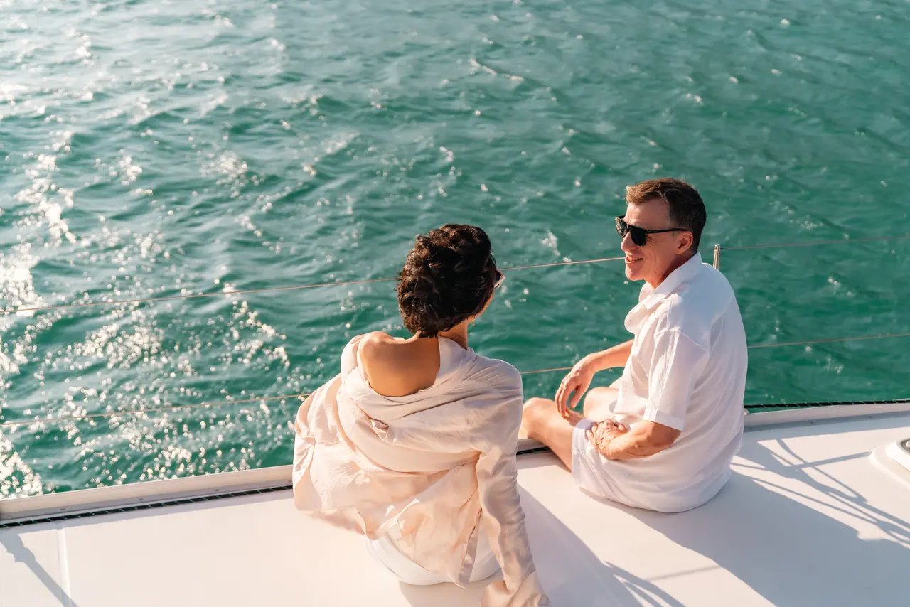 Una pareja amorosa disfrutando de unas románticas vacaciones en un crucero, rodeada de vistas al mar, cálida luz del sol y momentos inolvidables juntos.