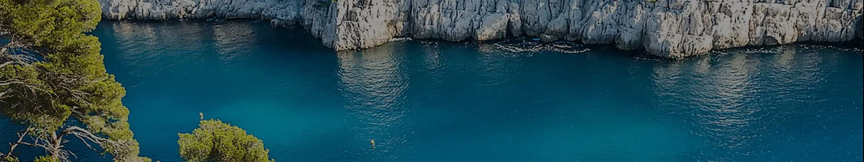Turquoise water meets dramatic limestone cliffs along France's calanques coastline, one of the striking Mediterranean landscapes Ponant sails past.