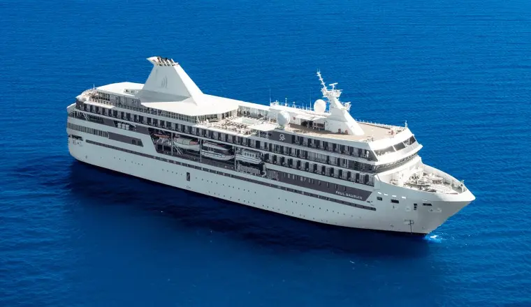 The m/s Paul Gauguin sails alone across open deep-blue waters, her compact silhouette built to carry just 330 guests through the South Pacific.