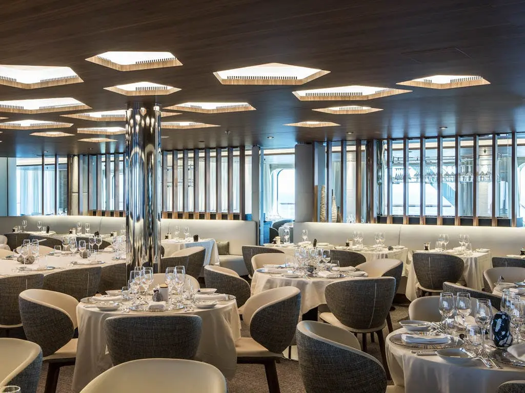 The Nuna restaurant aboard Le Commandant Charcot showcases Alain Ducasse-designed dining, pairing sleek Nordic-inspired design with fine cuisine at se